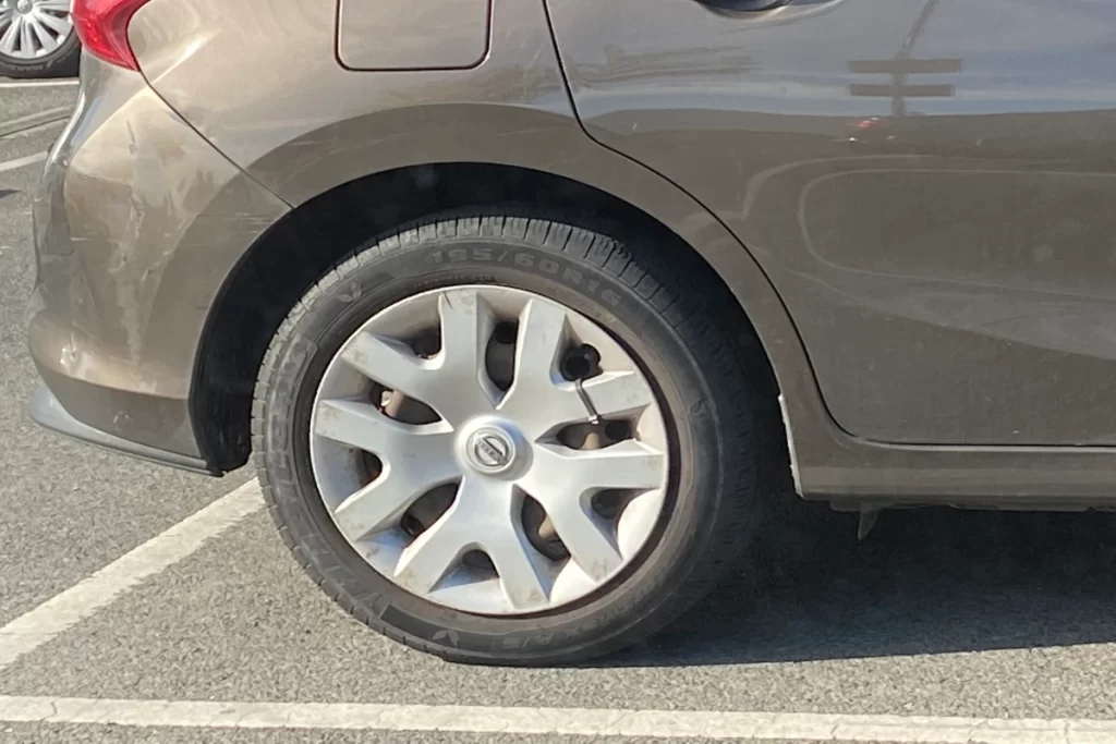 Nissan car plastic wheel cover secured to rim