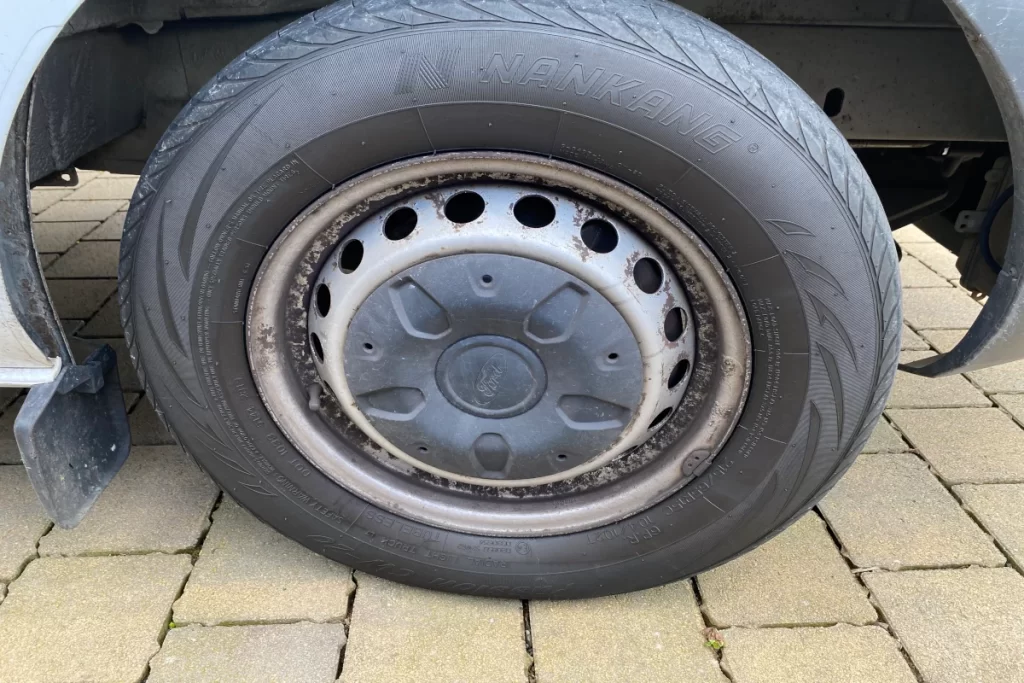 Ford van steel wheel with metal hubcap covering Hub and Lug nuts