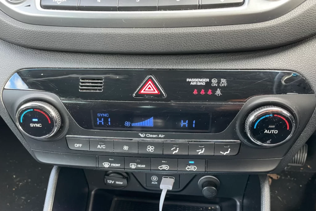 Hyundai Tucson climate control heating is switched on with the blower at full speed.