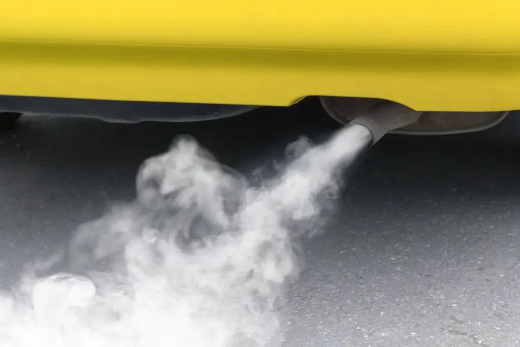 Yellow car exhaust pipe emitting fumes